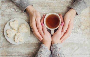 çay aşıkların eller. Ahşap arka plan üzerinde.