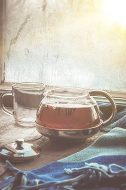 sıcak çay pencerenin yakınındaki tencerede. seçici odak.