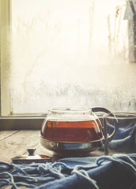 sıcak çay pencerenin yakınındaki tencerede. seçici odak.