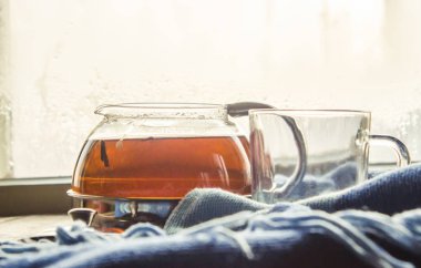 sıcak çay pencerenin yakınındaki tencerede. seçici odak.