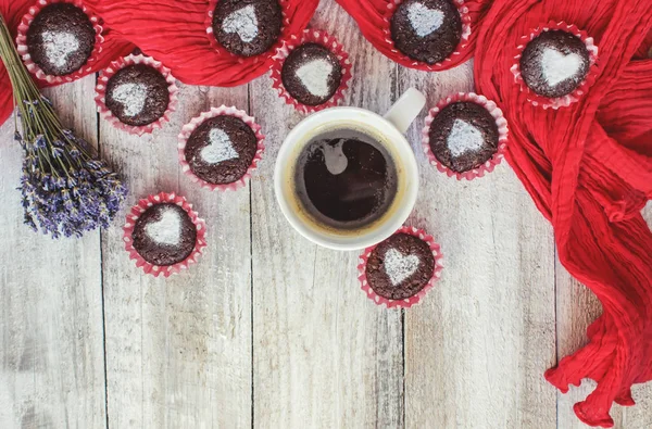 Homemade chocolate cupcakes with hearts and a Cup of coffee for Breakfast. Selective focus. Wooden background. — Stock Photo, Image