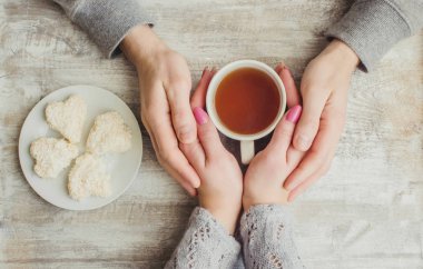 çay aşıkların eller. Ahşap arka plan üzerinde.