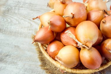Ahşap zemin üzerine soğan orta boy sepet. seçici odak. 