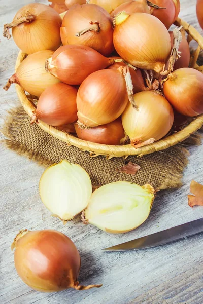 Ahşap zemin üzerine soğan orta boy sepet. seçici odak. 