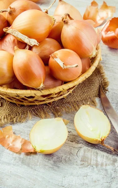 Basket of onion medium size on wooden background. selective focus. — Stock Photo, Image