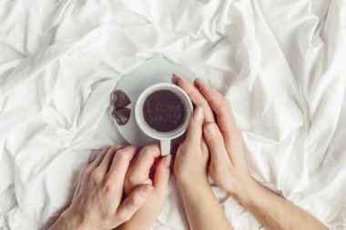 lovers holding together a Cup of coffee. Selective focus.