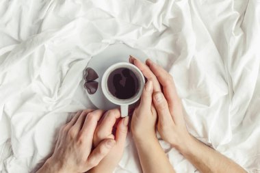 lovers holding together a Cup of coffee. Selective focus.