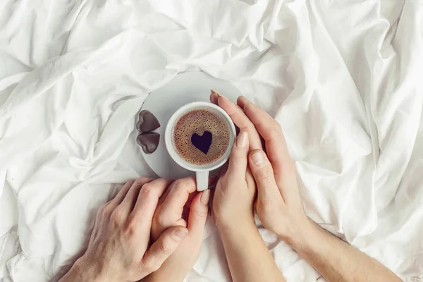 Amantes segurando juntos uma xícara de café. Foco seletivo . — Fotografia de Stock