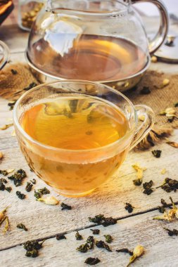 Yasemin ve siyah hafif bir arka plan üzerinde küçük bir fincan şeffaf limonlu yeşil çay. Çay makinesi. Seçici odak.