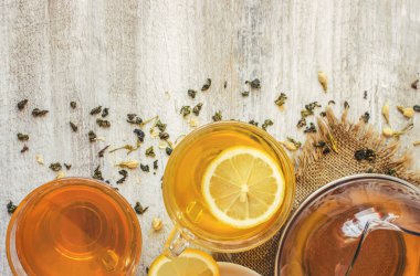 Yasemin ve siyah hafif bir arka plan üzerinde küçük bir fincan şeffaf limonlu yeşil çay. Çay makinesi. Seçici odak.