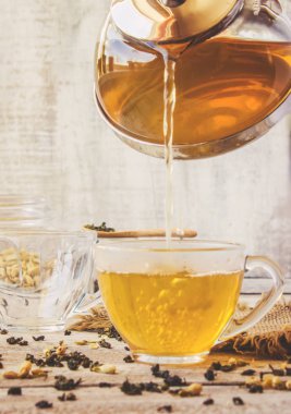 Yasemin ve siyah hafif bir arka plan üzerinde küçük bir fincan şeffaf limonlu yeşil çay. Çay makinesi. Seçici odak.