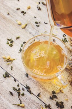 Yasemin ve siyah hafif bir arka plan üzerinde küçük bir fincan şeffaf limonlu yeşil çay. Çay makinesi. Seçici odak.