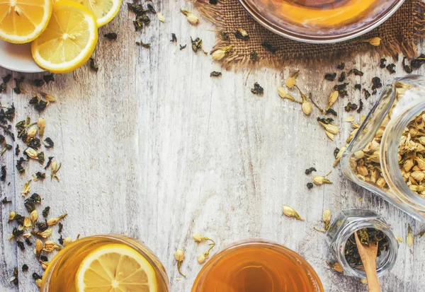 Green tea with Jasmine and black with transparent lemon in a small Cup on a light background. The tea maker. Selective focus. — Stock Photo, Image