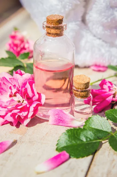 Aceite esencial de rosas rosadas en un frasco pequeño. Enfoque selectivo . —  Fotos de Stock