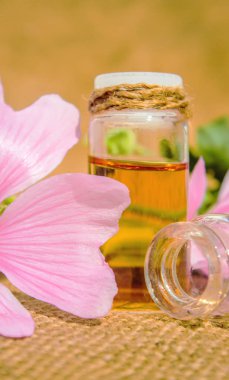 küçük bir kavanoza ebegümeci özü. Seçici odak. 