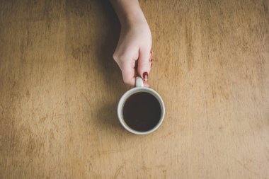 Bir fincan kahve kahvaltı onun elinde. Seçici odak. 