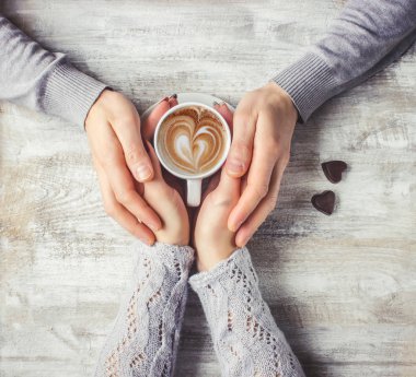 Aşıkların elinde kahvaltı için bir bardak içki. Seçici odak. 