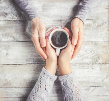 Aşıkların elinde kahvaltı için bir bardak içki. Seçici odak. 