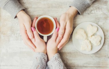 Aşıkların elinde kahvaltı için bir bardak içki. Seçici odak. 