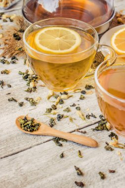 Yasemin ve siyah hafif bir arka plan üzerinde küçük bir fincan şeffaf limonlu yeşil çay. Çay makinesi. Seçici odak.