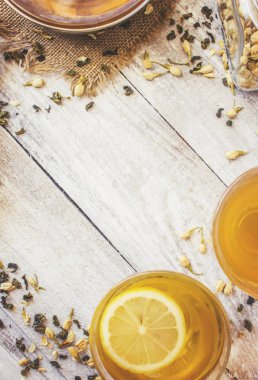 Yasemin ve siyah hafif bir arka plan üzerinde küçük bir fincan şeffaf limonlu yeşil çay. Çay makinesi. Seçici odak.