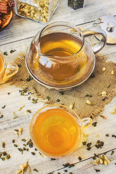 Green tea with Jasmine and black with transparent lemon in a small Cup on a light background. The tea maker. Selective focus. — Stock Photo, Image