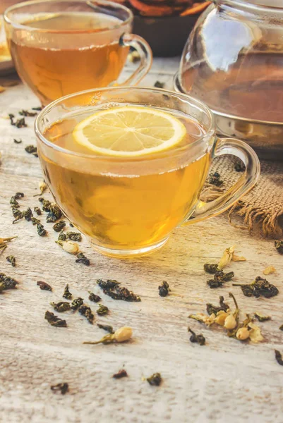 Πράσινο τσάι με γιασεμί και μαύρο με διαφανή λεμονιού σε ένα μικρό φλιτζάνι σε ανοιχτόχρωμο φόντο. Το τσάι. Επιλεκτική εστίαση. — Φωτογραφία Αρχείου