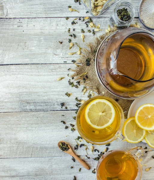 Té verde con jazmín y negro con limón transparente en una taza pequeña sobre un fondo claro. La tetera. Enfoque selectivo . — Foto de Stock