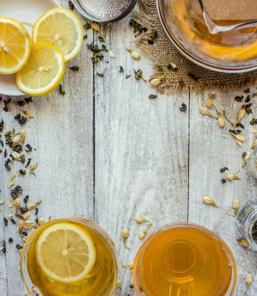 Green tea with Jasmine and black with transparent lemon in a small Cup on a light background. The tea maker. Selective focus.