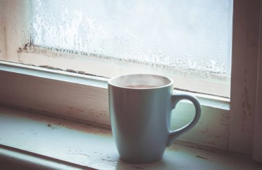 sıcak çay Kupası'nda pencere üzerinde. seçici odak. 