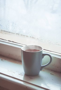 sıcak çay Kupası'nda pencere üzerinde. seçici odak. 