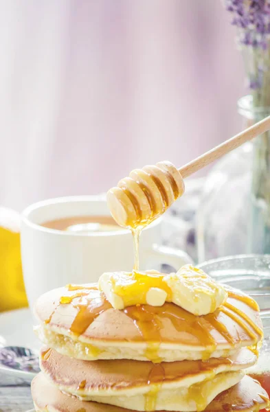 Pfannkuchen mit Butter und Honig und Zitronentee zum Frühstück. Selektiver Fokus. — Stockfoto