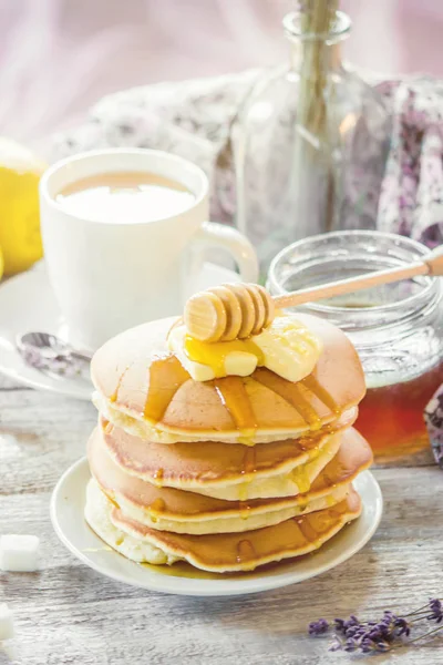 Pancakes with butter and honey and lemon tea for Breakfast. selective focus. — Stock Photo, Image