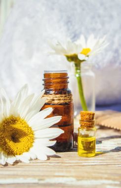 Papatya uçucu yağ küçük bir şişe içinde. Seçici odak.