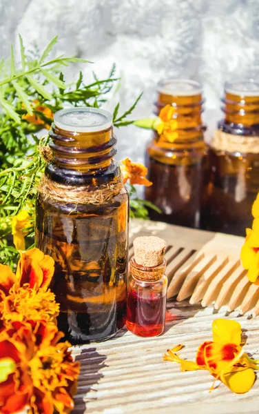Essential oil of chernobrivtsev, marigold in a small bottle. Selective focus. — Stock Photo, Image