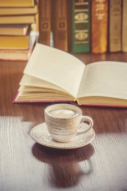 Kahve sabah işyerinde. bir kitap ya da dizüstü bilgisayar ile. seçici odak.