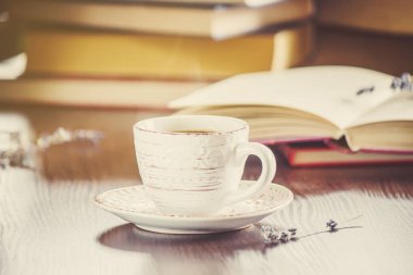 Kahve sabah işyerinde. bir kitap ya da dizüstü bilgisayar ile. seçici odak.