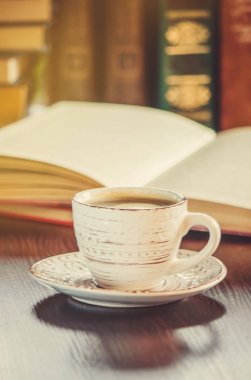 Kahve sabah işyerinde. bir kitap ya da dizüstü bilgisayar ile. seçici odak.