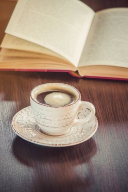 Kahve sabah işyerinde. bir kitap ya da dizüstü bilgisayar ile. seçici odak.