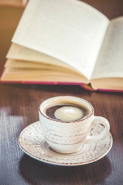 Kahve sabah işyerinde. bir kitap ya da dizüstü bilgisayar ile. seçici odak.
