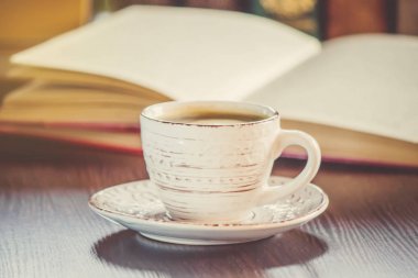 Kahve sabah işyerinde. bir kitap ya da dizüstü bilgisayar ile. seçici odak.