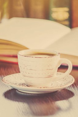 Kahve sabah işyerinde. bir kitap ya da dizüstü bilgisayar ile. seçici odak.