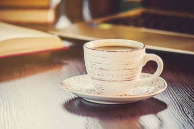 Kahve sabah işyerinde. bir kitap ya da dizüstü bilgisayar ile. seçici odak.