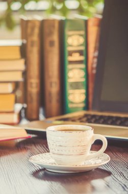 Kahve sabah işyerinde. bir kitap ya da dizüstü bilgisayar ile. seçici odak.