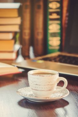 Kahve sabah işyerinde. bir kitap ya da dizüstü bilgisayar ile. seçici odak.