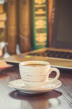 Kahve sabah işyerinde. bir kitap ya da dizüstü bilgisayar ile. seçici odak.