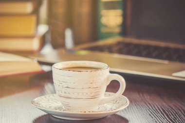 Kahve sabah işyerinde. bir kitap ya da dizüstü bilgisayar ile. seçici odak.