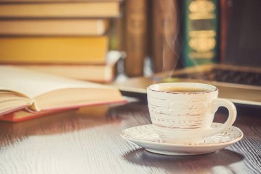 Kahve sabah işyerinde. bir kitap ya da dizüstü bilgisayar ile. seçici odak.