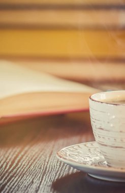 Kahve sabah işyerinde. bir kitap ya da dizüstü bilgisayar ile. seçici odak.