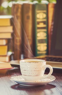 Kahve sabah işyerinde. bir kitap ya da dizüstü bilgisayar ile. seçici odak.